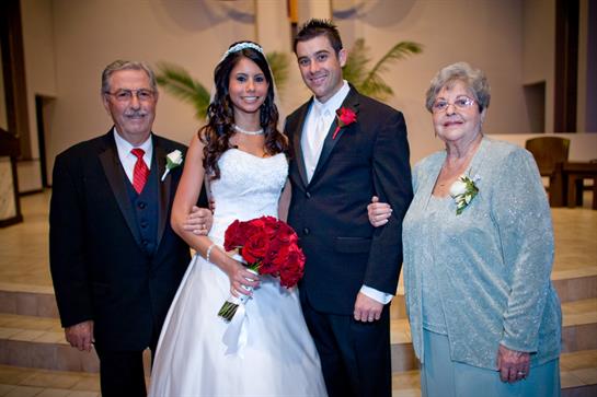 Bride and groom pose with their grandparents, surrounded by love and celebration at the wedding.