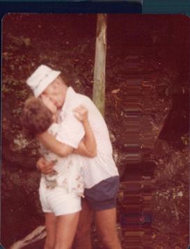 A couple embraces in a natural environment, enjoying a moment of affectionate intimacy.