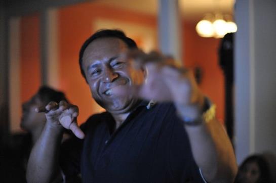 A person expresses happiness while enjoying a lively gathering with friends at night.