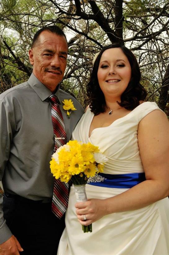 A couple stands joyfully in a garden adorned with spring flowers, embracing their special day.