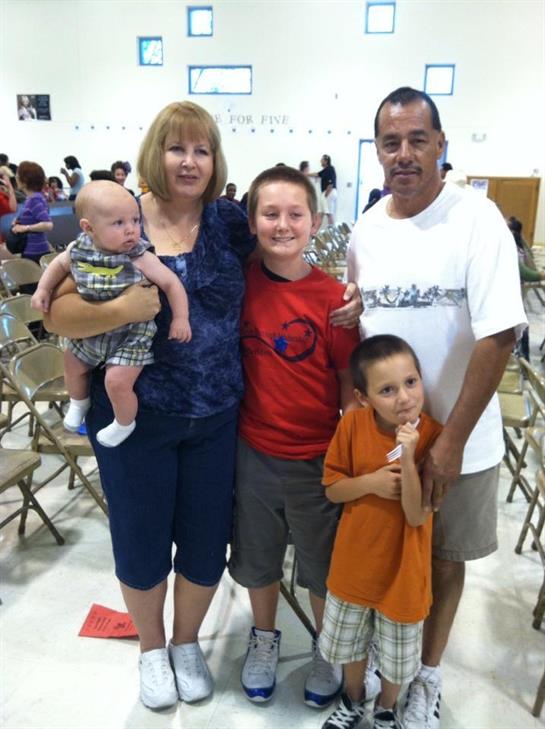 A joyful family poses together at a community center event with children and adults smiling happily.