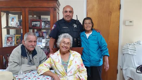Family and officer share smiles in a warm, inviting living room filled with memories.