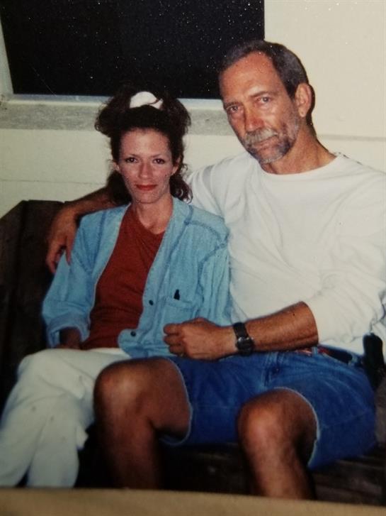 Two people are seated together on a couch, enjoying a relaxed moment in a comfortable environment.