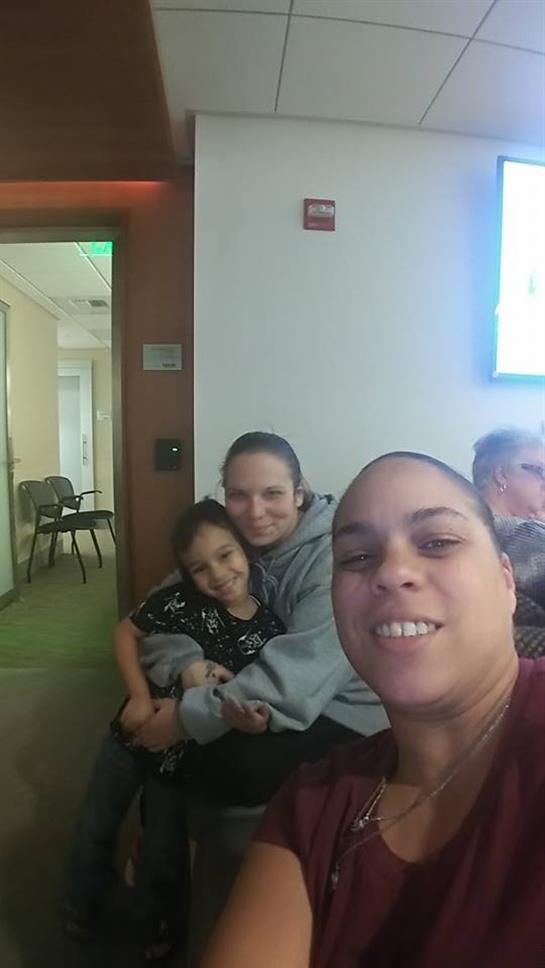 Family members smile and pose for a selfie, enjoying quality time together indoors.