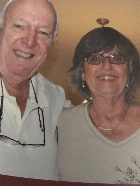 A couple shares a joyful moment with friends at a lively social event.