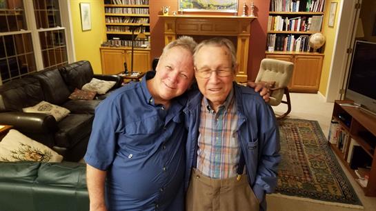 Friends enjoying each other's company in a comfortable indoor space, surrounded by books and warmth.