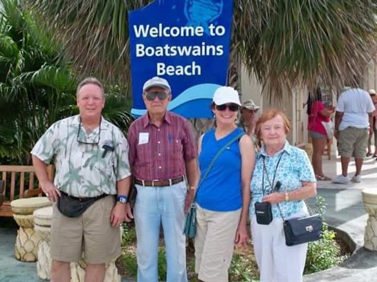 Tourists pose at Boatswains Beach, enjoying the sun and the beautiful scenery together.