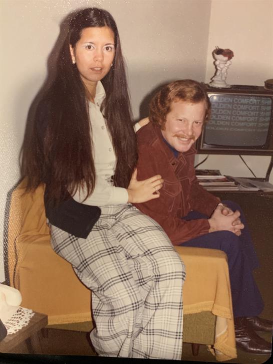 Two friends enjoy their time together in a vintage living room, laughing and relaxing.