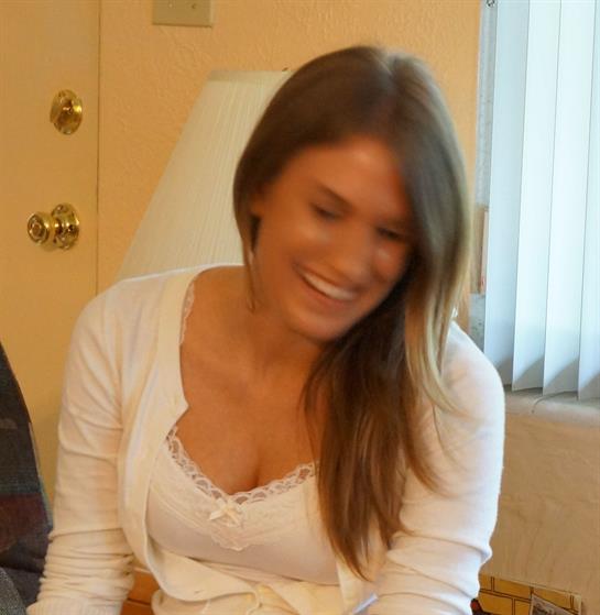 Friends laugh and smile together in a cozy, warmly lit space of friendship.