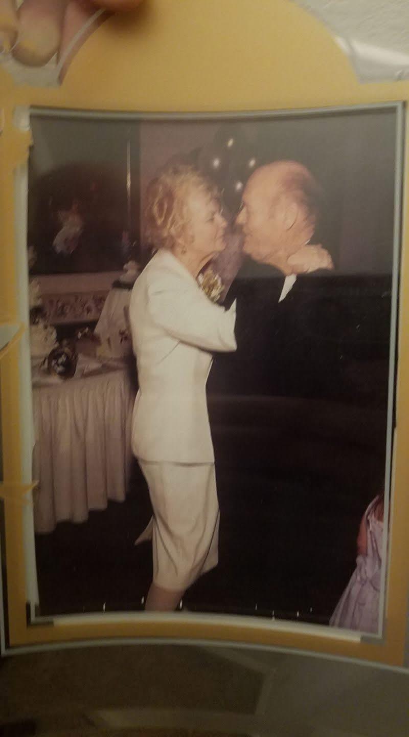 An elderly couple shares a joyful dance, surrounded by a festive atmosphere filled with decorations.