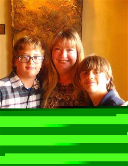 Three people with smiles pose together in a warm, inviting atmosphere of a cafe.