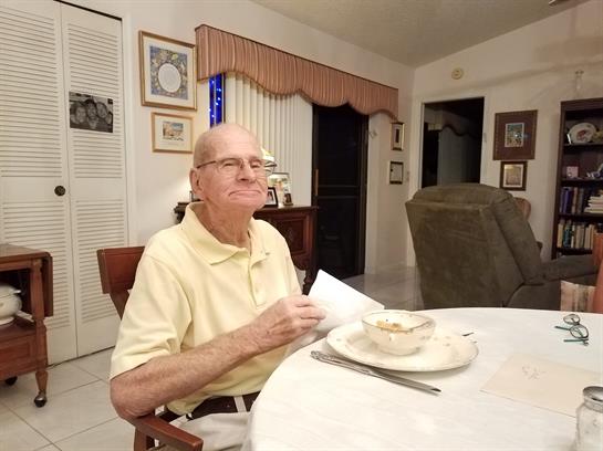 A man sitting at a table with a bowl of soup