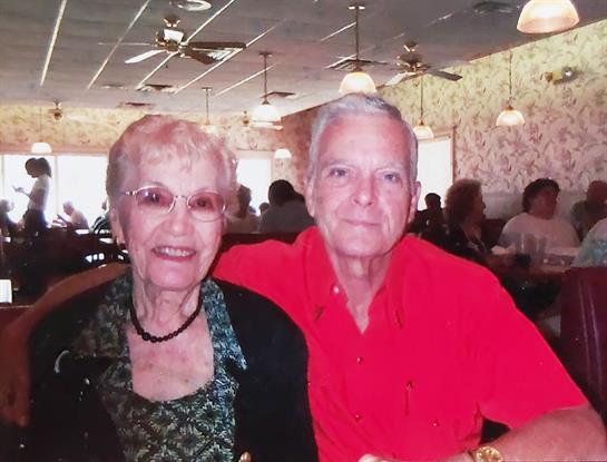 An elderly couple shares a joyful lunch together at a restaurant.