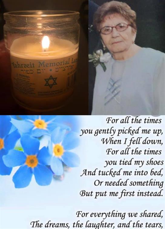 Candlelight illuminates a tribute, showcasing a portrait, a poem of love, and blue flowers.