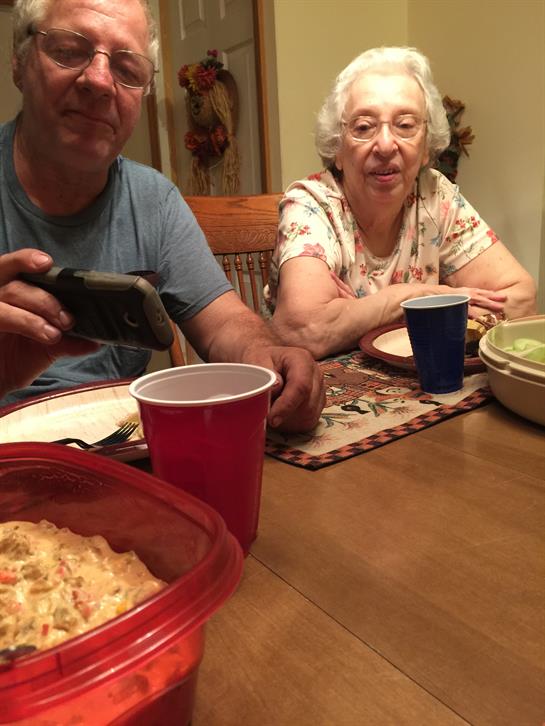 Family members engage in lively conversation while sharing a meal at the dining table.