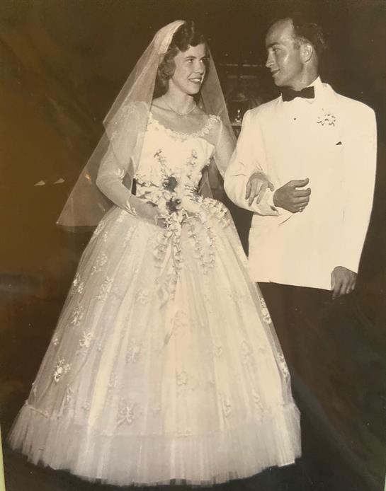 Couple dressed in formal attire shares a joyful moment on their wedding day at an elegant venue.