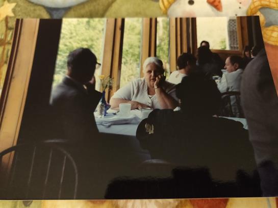 Patrons enjoy their meals at a warmly lit restaurant, sharing stories and laughter among friends.