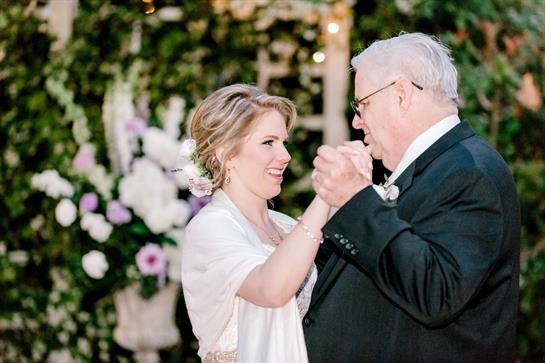 A heartfelt moment shared between a bride and her father during a wedding dance.