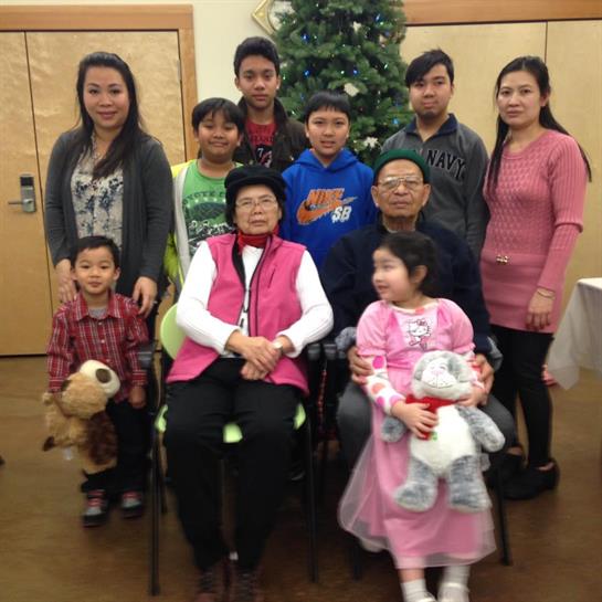 A joyful family celebrates together by a decorated tree, sharing smiles and laughter.