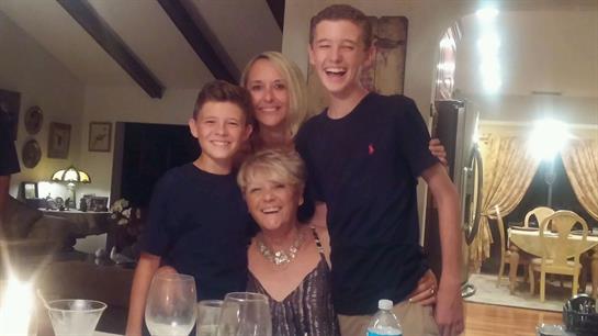 Four family members share a joyful moment at home, enjoying each other's company.