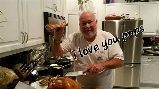 A joyful chef holds a turkey leg while slicing a turkey in a warm kitchen setting.