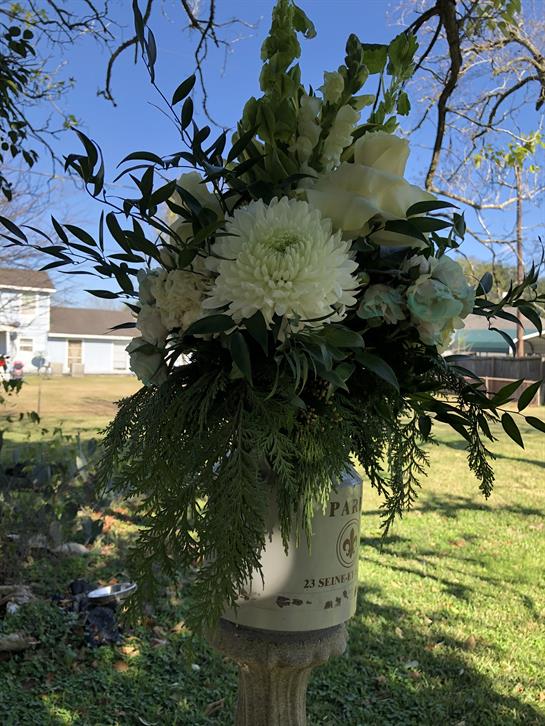 Bright white flowers and lush greenery arranged beautifully in a tranquil outdoor environment.