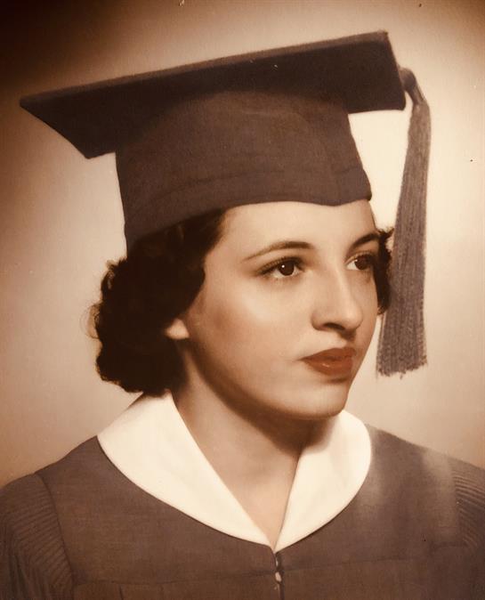 A young woman celebrates her graduation in her cap and gown, embracing her future.