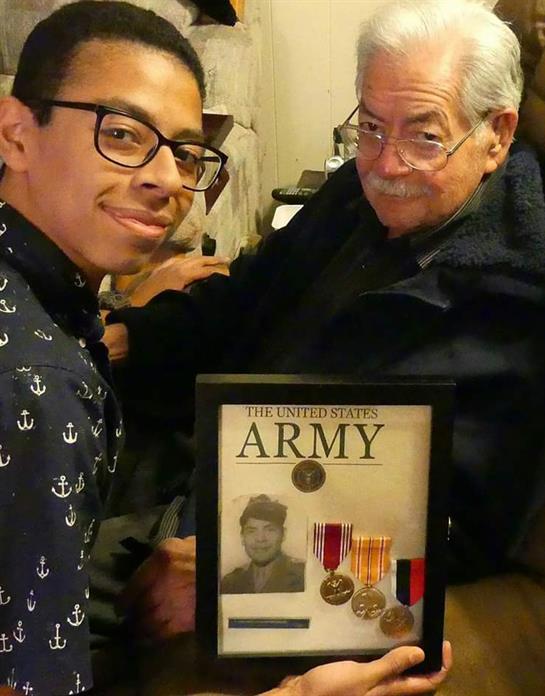 A young man and his grandfather celebrate military achievements and family legacy.