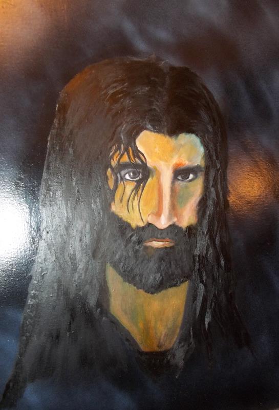 A detailed portrait features a bearded man with long hair, capturing deep emotion and intensity.