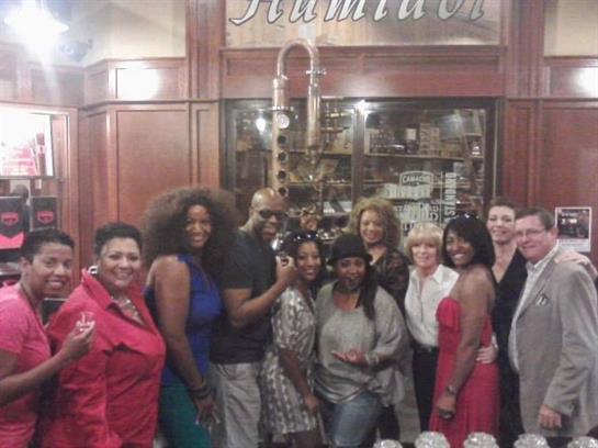 Friends enjoy each other's company, posing together in a stylish venue with warm lighting.