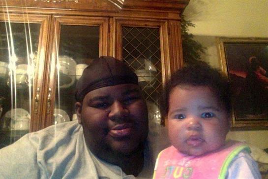 A joyful father smiles with his baby girl in their home, showcasing their close bond and happiness.