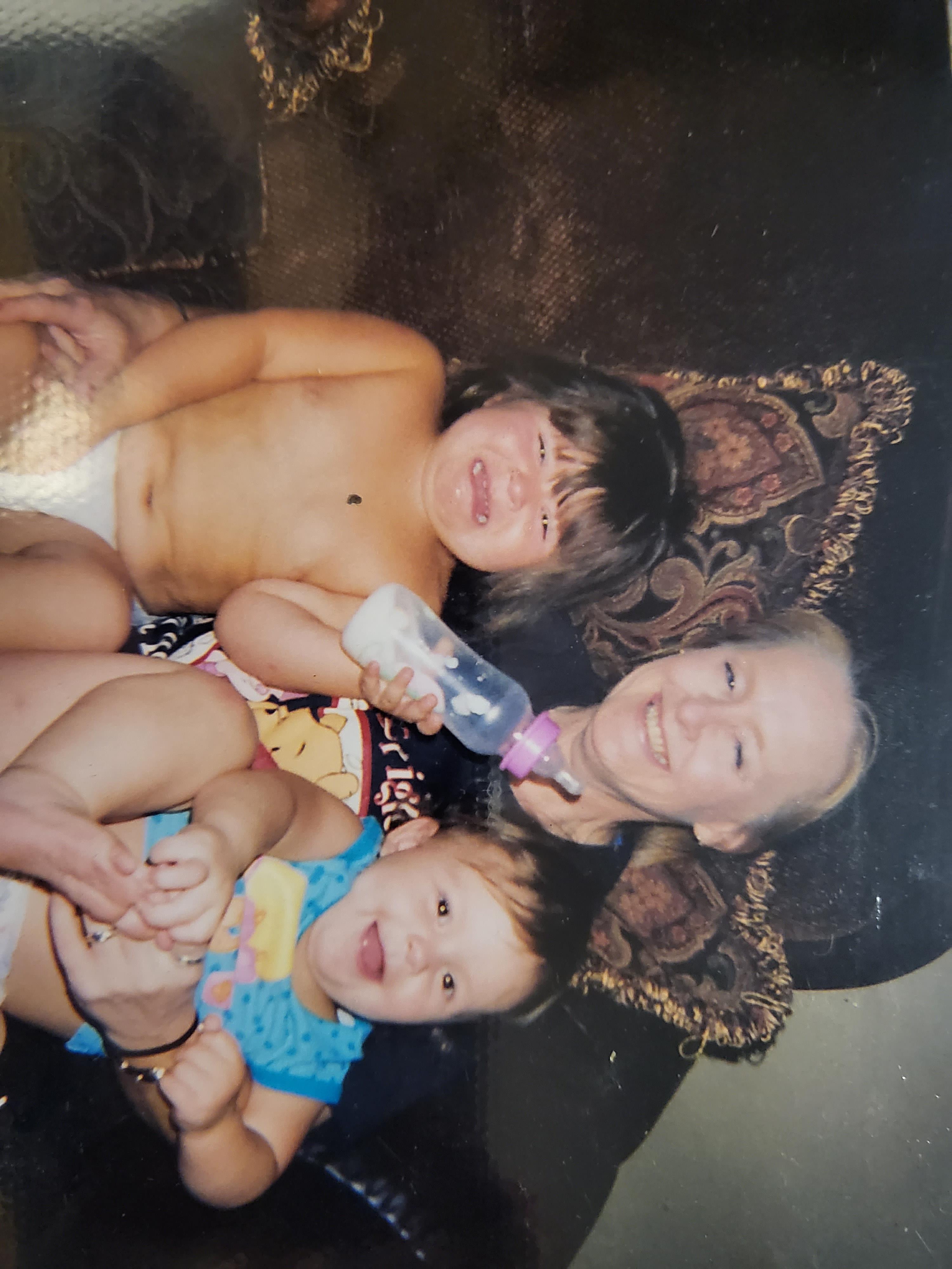 Three young children are happily engaging with an adult, creating joyful memories.