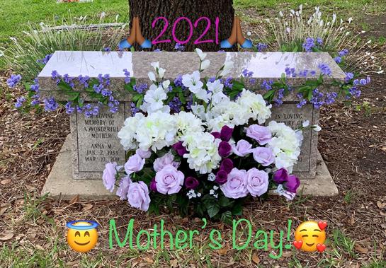 A vibrant arrangement of flowers is placed on a grave honoring Mother's Day in 2021.