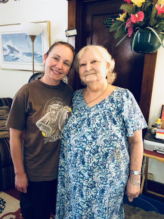 Two women enjoy each other's company with smiles, surrounded by a warm and inviting interior.