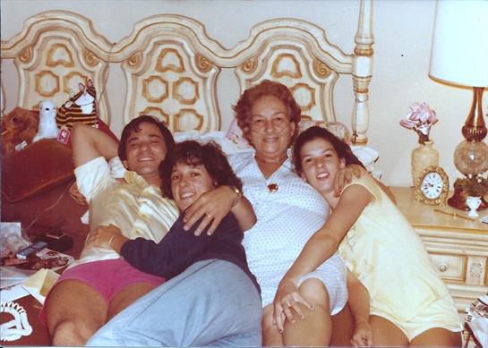 Four family members relax and share smiles while lounging on a couch, creating cherished memories.