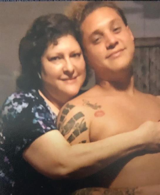 A heartfelt moment is captured as two family members share a loving embrace indoors.