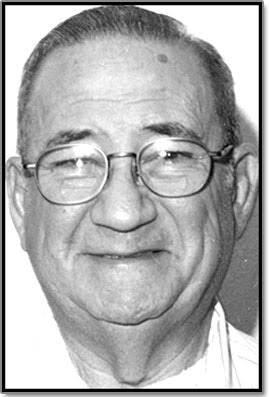 A senior man with glasses displays a cheerful smile, conveying warmth and friendliness.