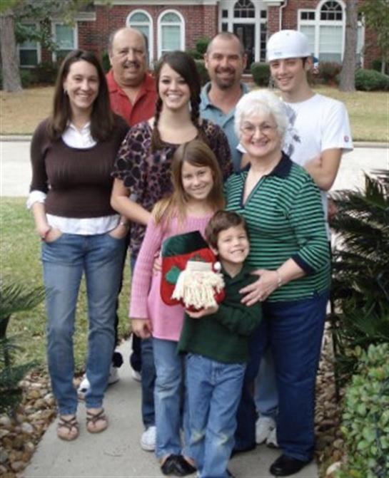 A joyful family stands together outdoors, celebrating and posing for a memorable group moment.