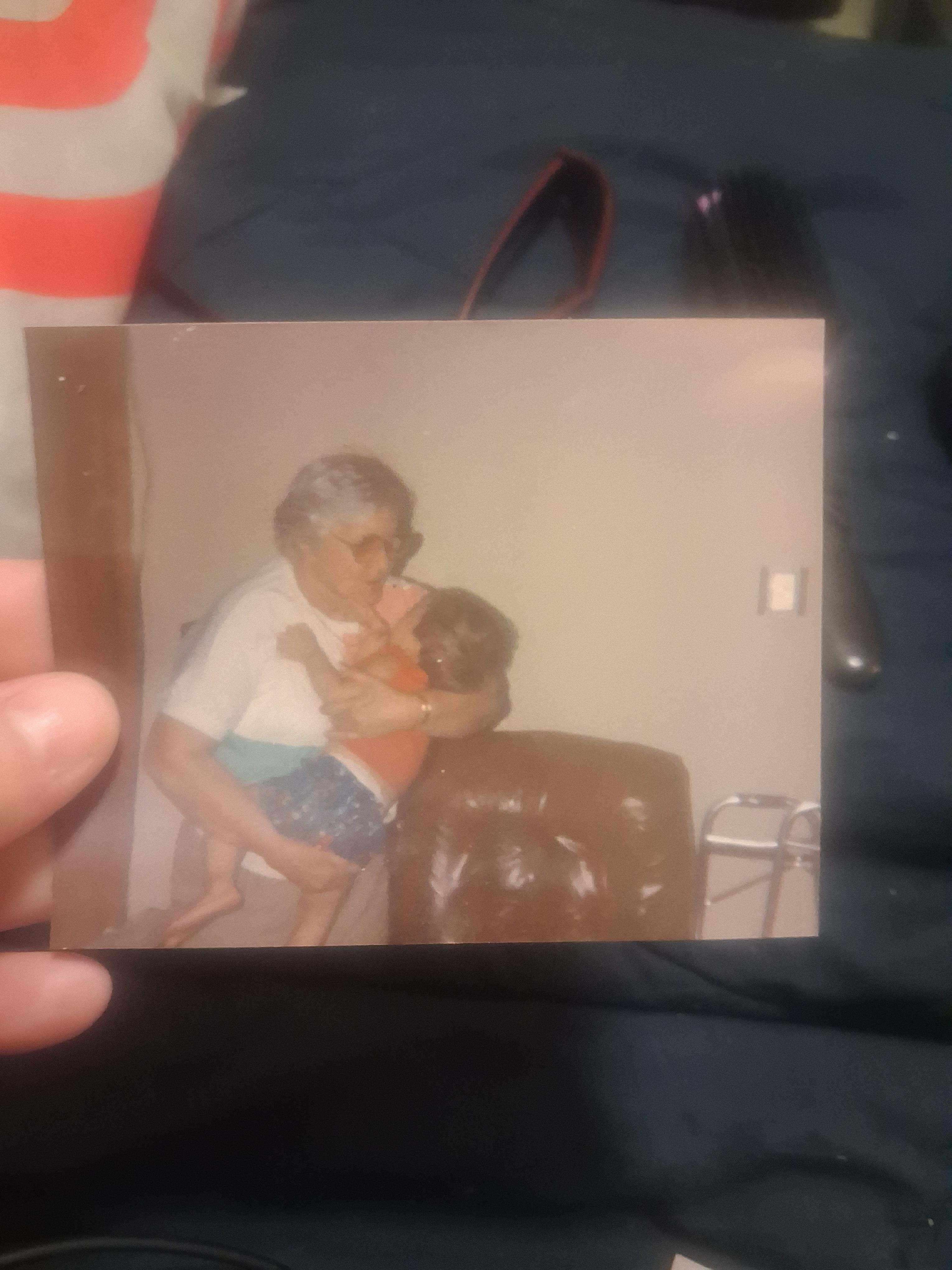 Elderly person lovingly embraces a small child in a comfortable home setting.