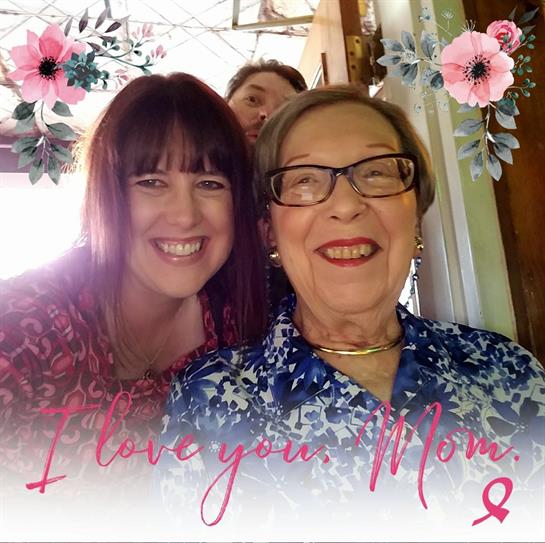 Daughter and mother share smiles as they pose for a photo in a cozy indoor setting.