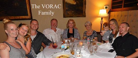 A joyous family gathering features four adults enjoying drinks and conversations at a dinner table.