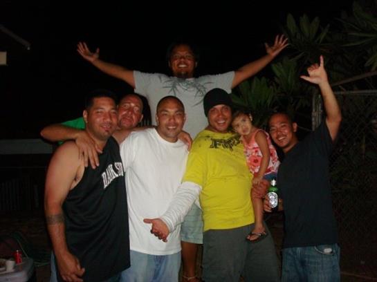 Group of friends smiling and posing together while enjoying a lively night outdoors.