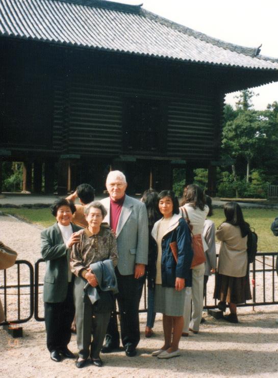Visitors pose in front of an ancient temple, capturing a moment together at a cultural site.
