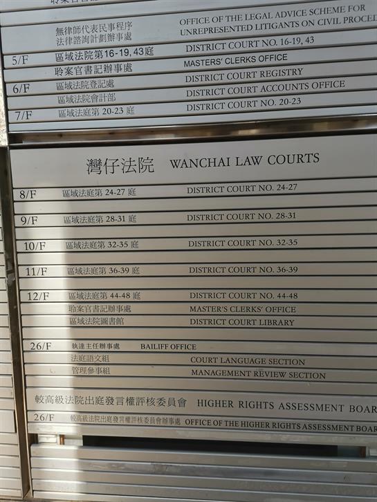 Signboard details multiple law courts and legal offices at Wanchai Law Courts in Hong Kong.