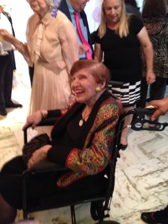 People enjoying a heartfelt moment together as one woman shares laughter in her wheelchair.
