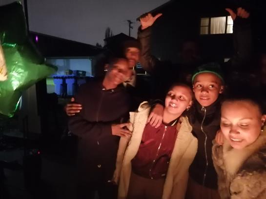 Friends enjoy a lively night gathering, sharing smiles and camaraderie under soft lighting.