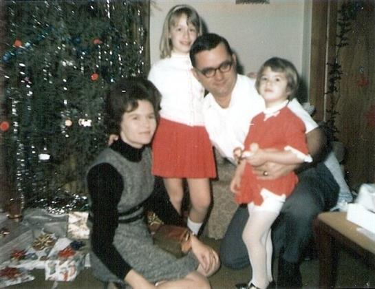 A family stands together in a warmly decorated living room, celebrating Christmas joyfully.