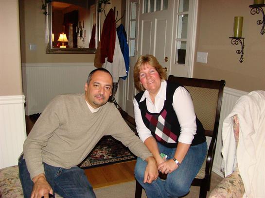 Two friends sit together, smiling and enjoying each other's company in a cozy indoor setting.