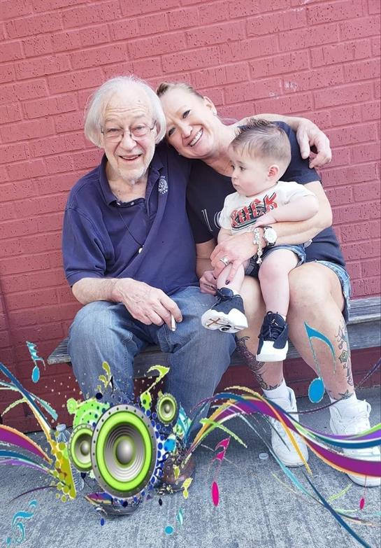 Three family members enjoy a joyful moment outdoors, showcasing affection and connection.