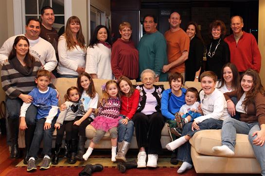 Family members of all ages gather in a warm living room for a joyful celebration and bonding.